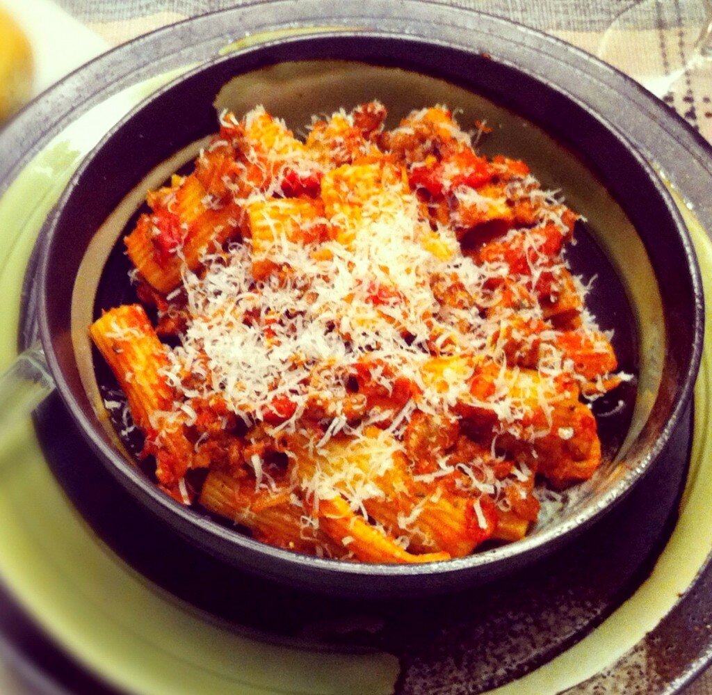 Rigatoni with Spicy Sausage and Bacon a bowl of rigatoni with meat sauce and parmesan cheese
